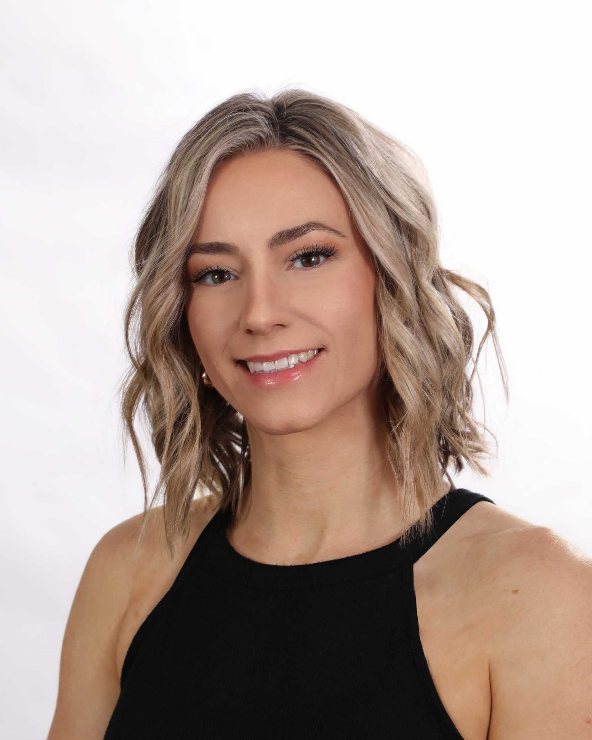 Portrait of Corinne, a professional stylist at Fusion Salon Avalon, showcasing their expertise and style.
